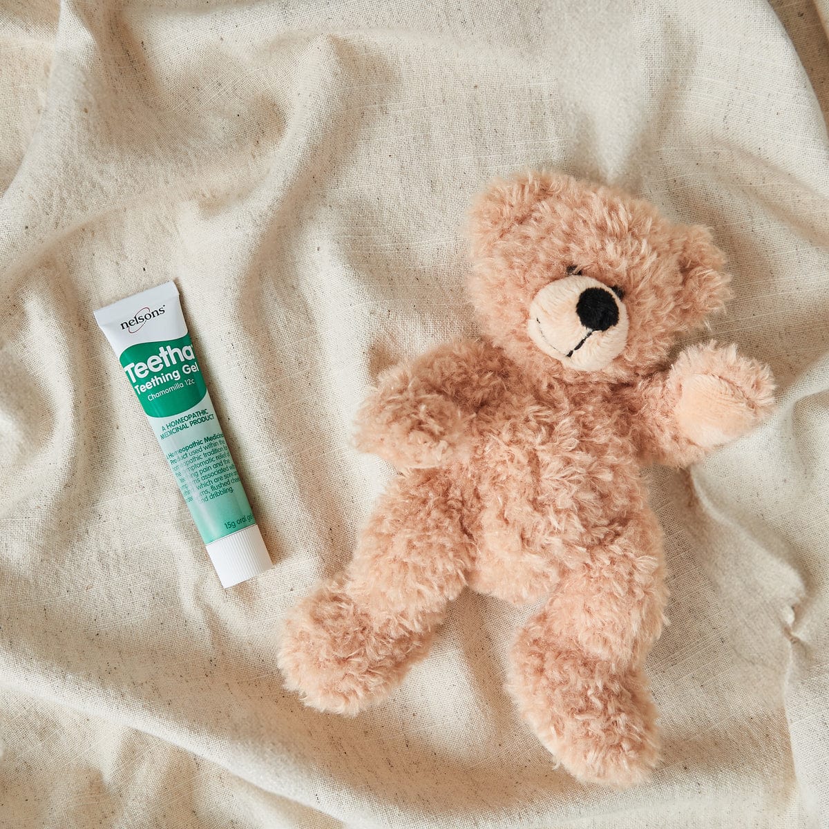 Nelsons Teetha® Teething Gel with teddy bear on bed