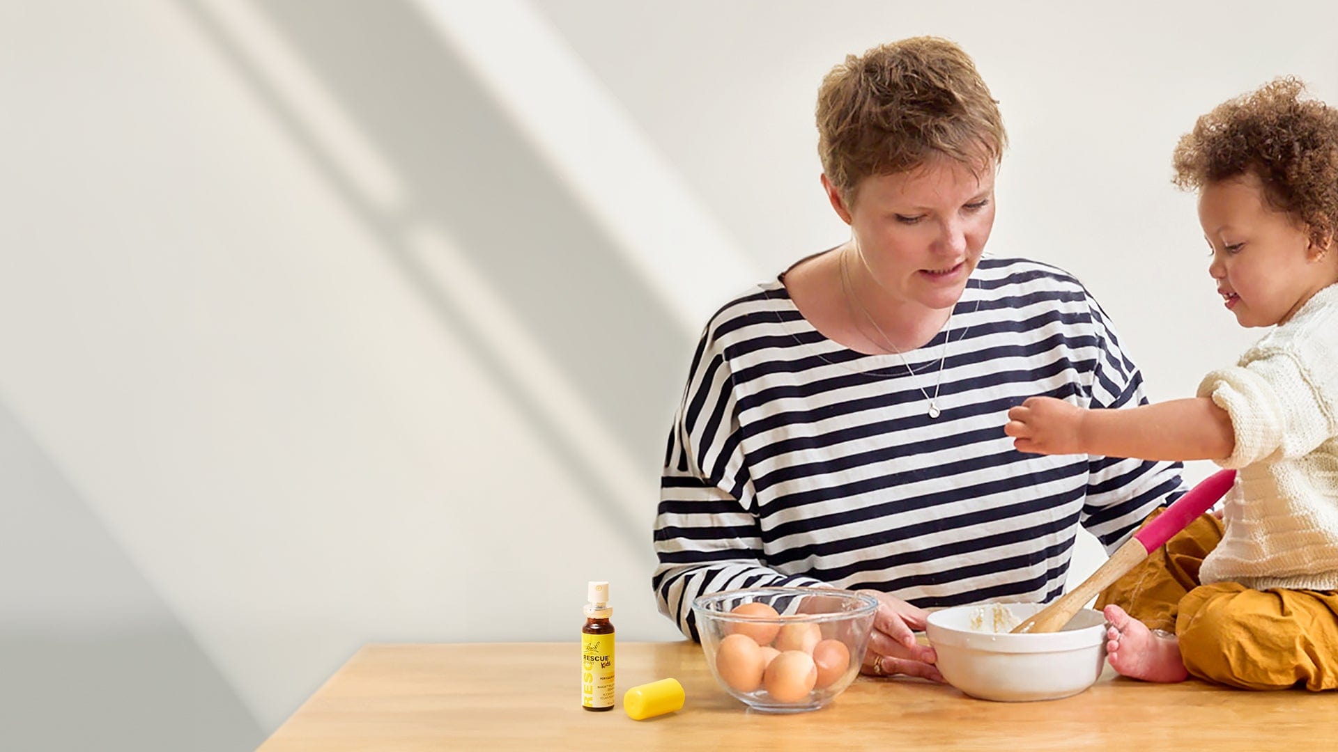 Mother and child baking a cake with a Rescue® Kids Spray if in times of need for the Childs emotional support