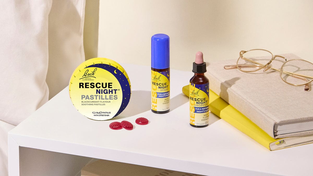 Rescue Night® Pastilles, 20ml Spray and 20ml Dropper on bed night stand with books and glasses for a natural nights sleep