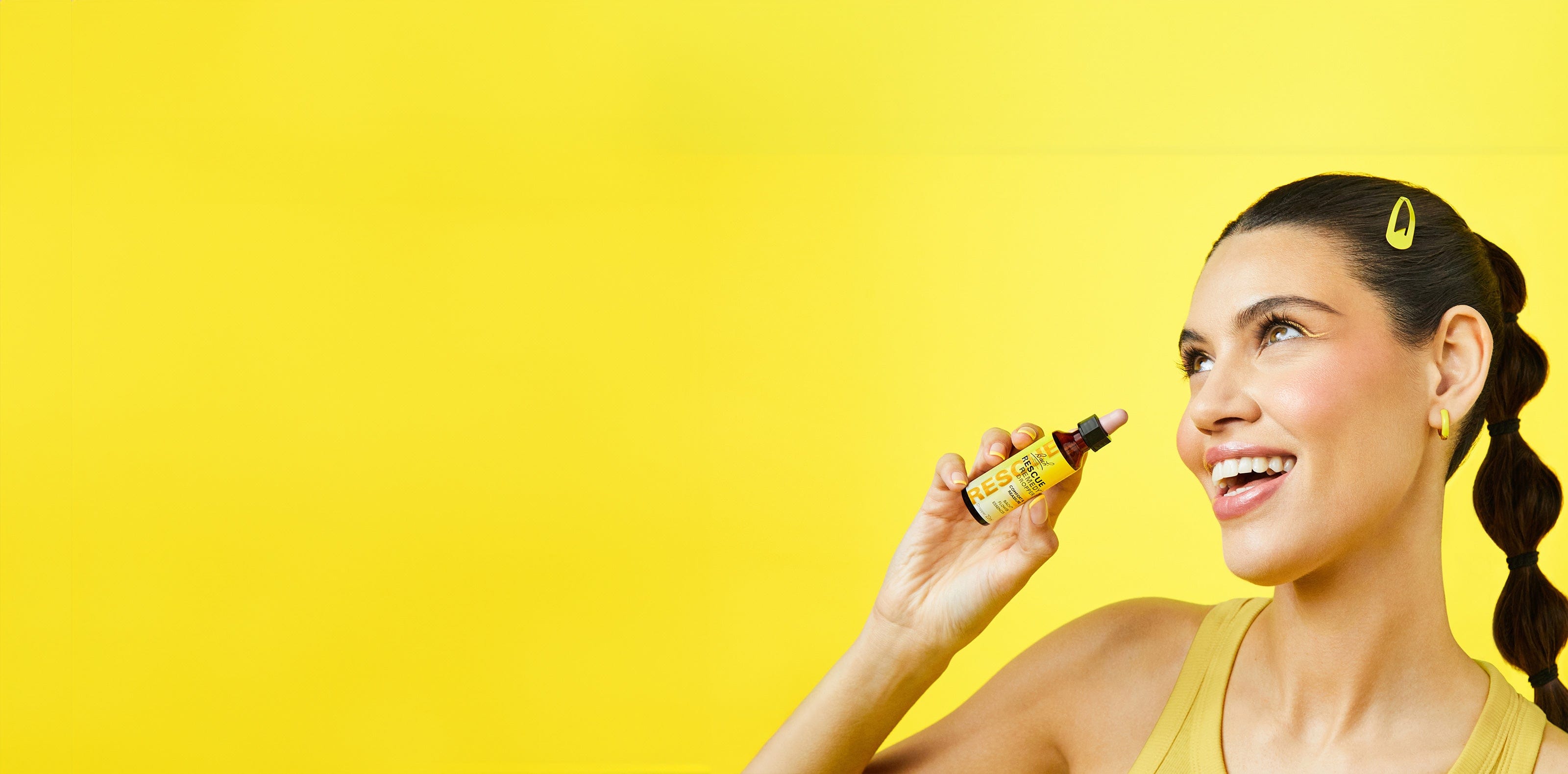 Happy young model holding Rescue Remedy Dropper 20ml