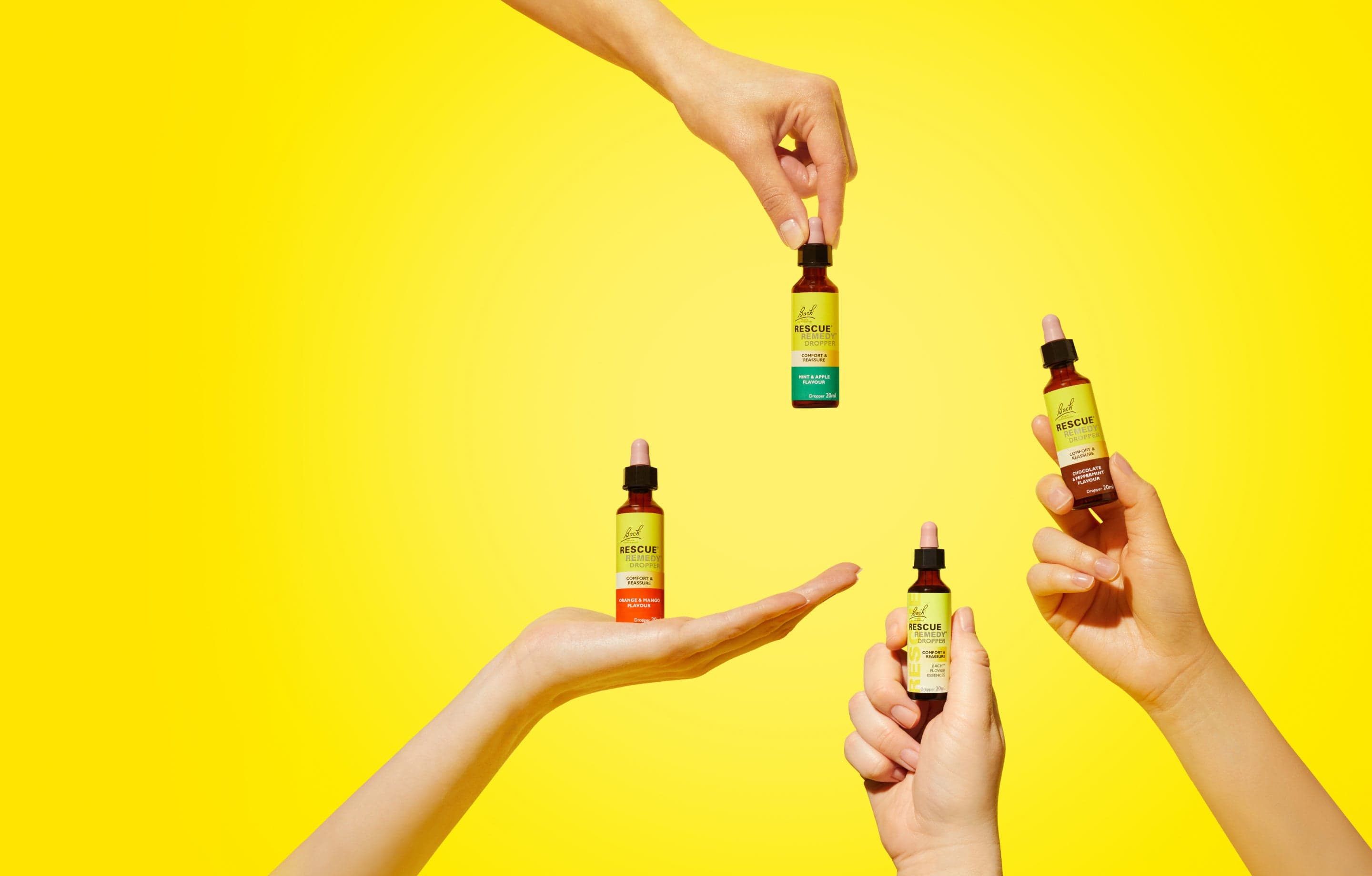 Hands reaching out with Rescue Remedy® 20ml Dropper, Orange & Mango Flavour Dropper, Chocolate & Peppermint Dropper and Mint & Apple Dropper