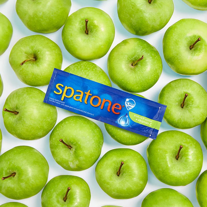 Spatone Iron-rich water with witamin C, apple flavour sachet surrounded by apples