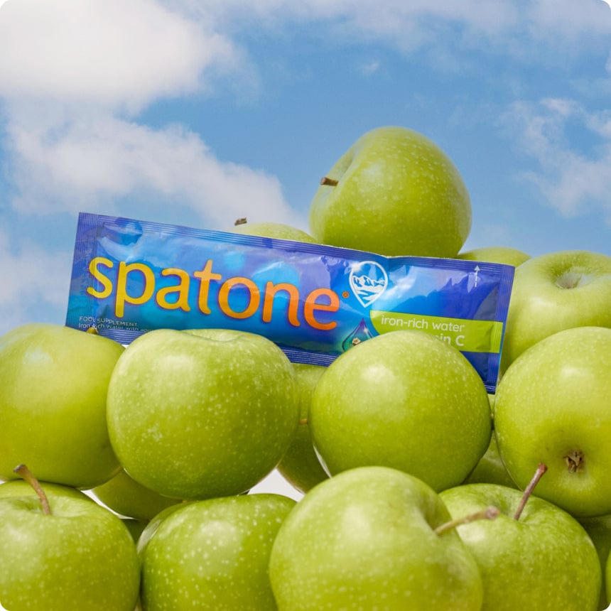 Spatone Iron-rich water with witamin C, apple flavour sachet surrounded by apples